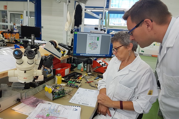 Nathalie Guede, opératrice à Anjou Electronique, et Arnaud Goulet, le directeur général de la PME, observent un gain de temps entre la fiche numérique et les différentes informations sur papier. ©CGM